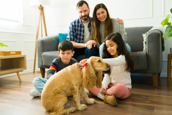 Riviera Apartments with a happy family relaxing at home and playing with their dog